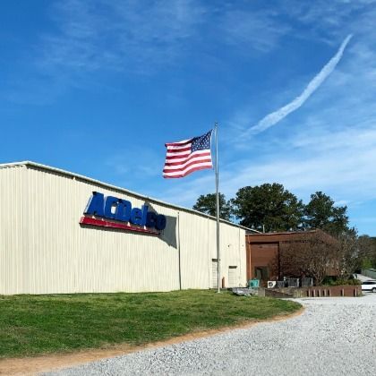 An american flag is flying in front of an acdelco building