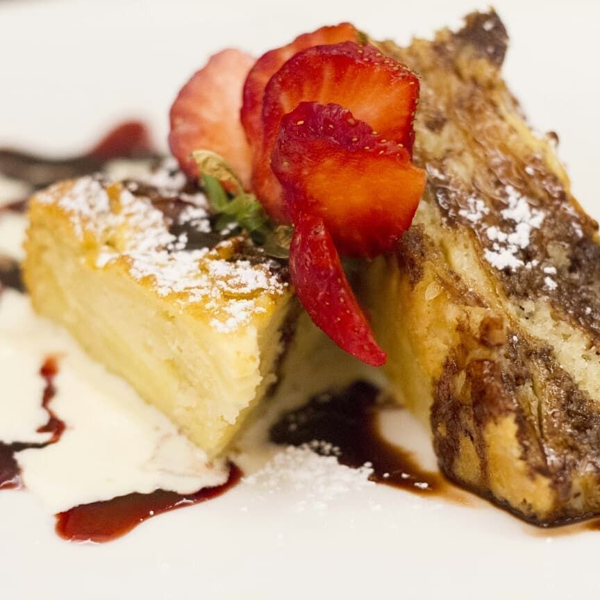 Una fetta di torta con sopra fragole e zucchero a velo