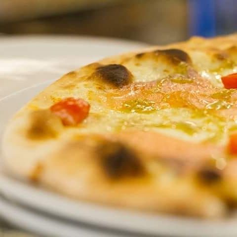 Un primo piano di una pizza su un piatto bianco.