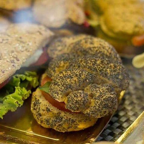 Un primo piano di un panino con semi di papavero su un vassoio.