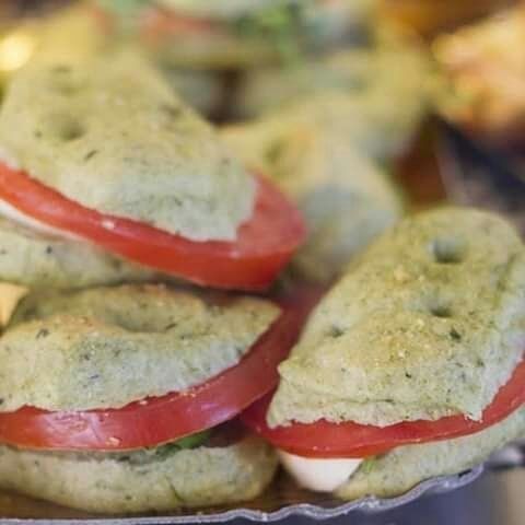 Un primo piano di un piatto di panini con pomodori e formaggio.