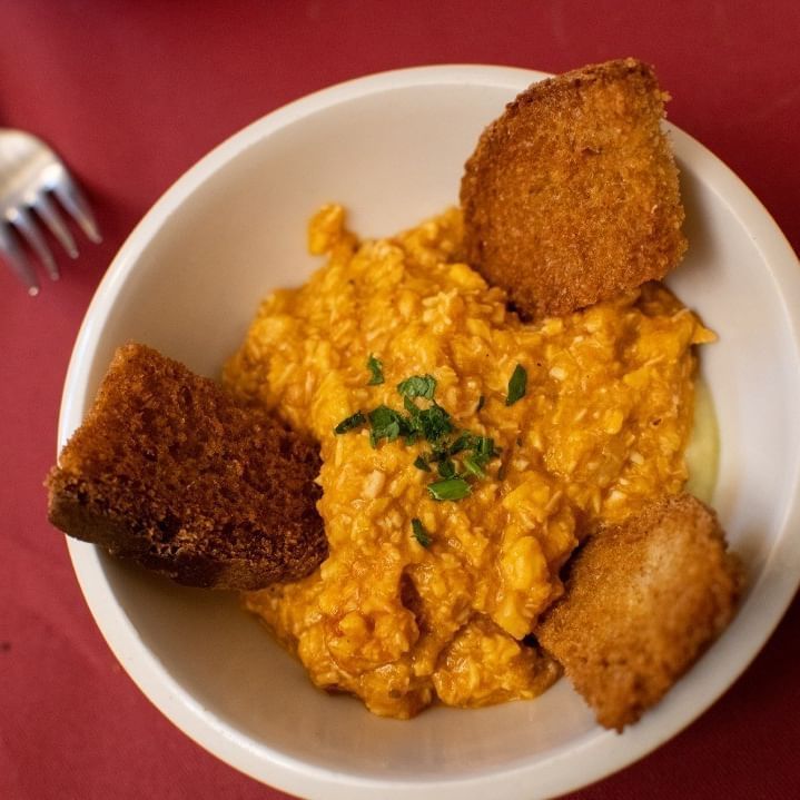 Una ciotola di cibo con una forchetta sullo sfondo