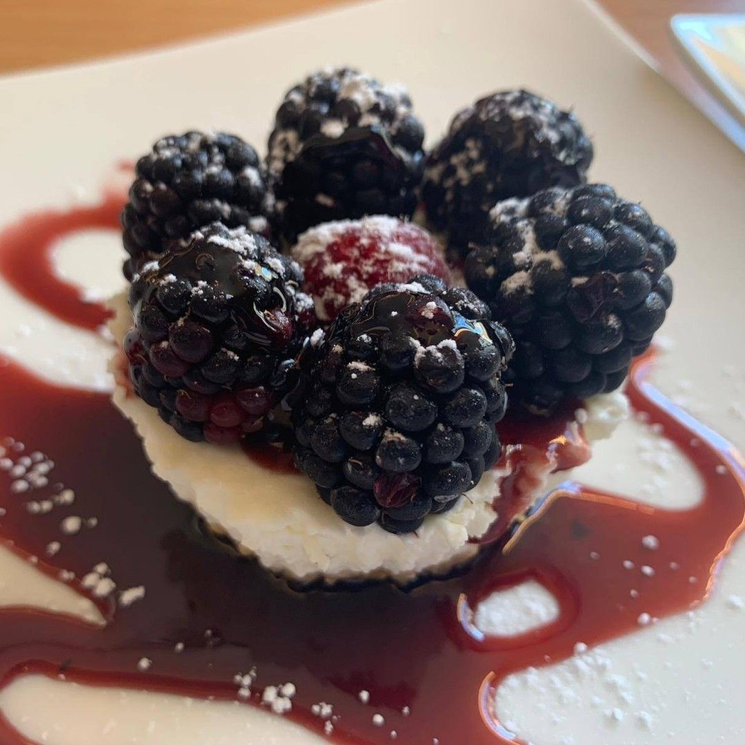 Un piatto bianco condito con more e panna montata