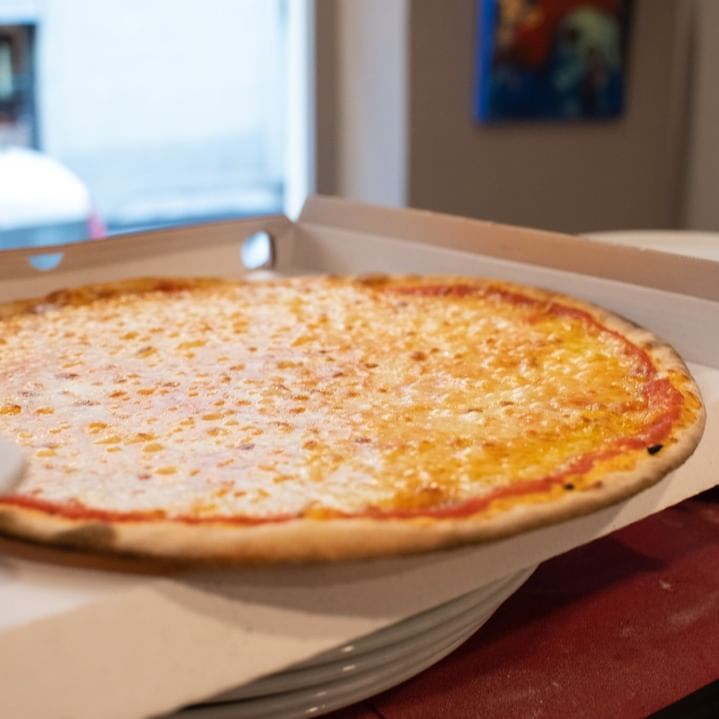 Una pizza è seduta in una scatola su un tavolo.