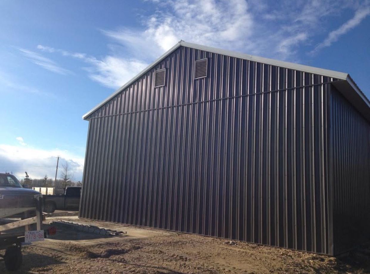 A large black building with a white truck parked in front of it.