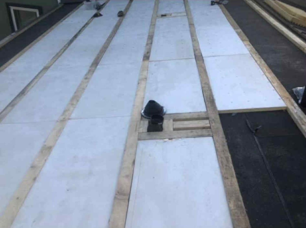 A white roof with wooden beams is being built.