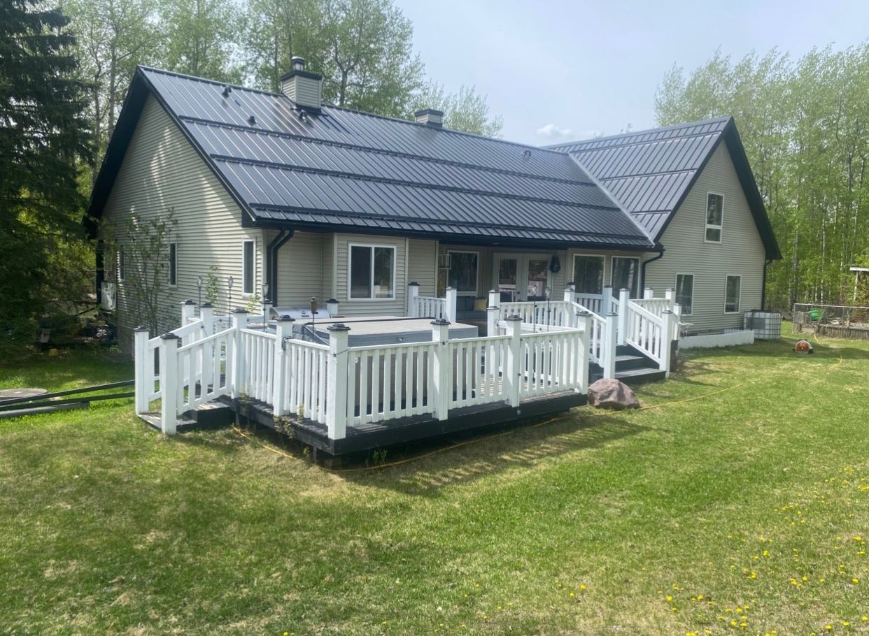 A large house with a large deck and solar panels on the roof.