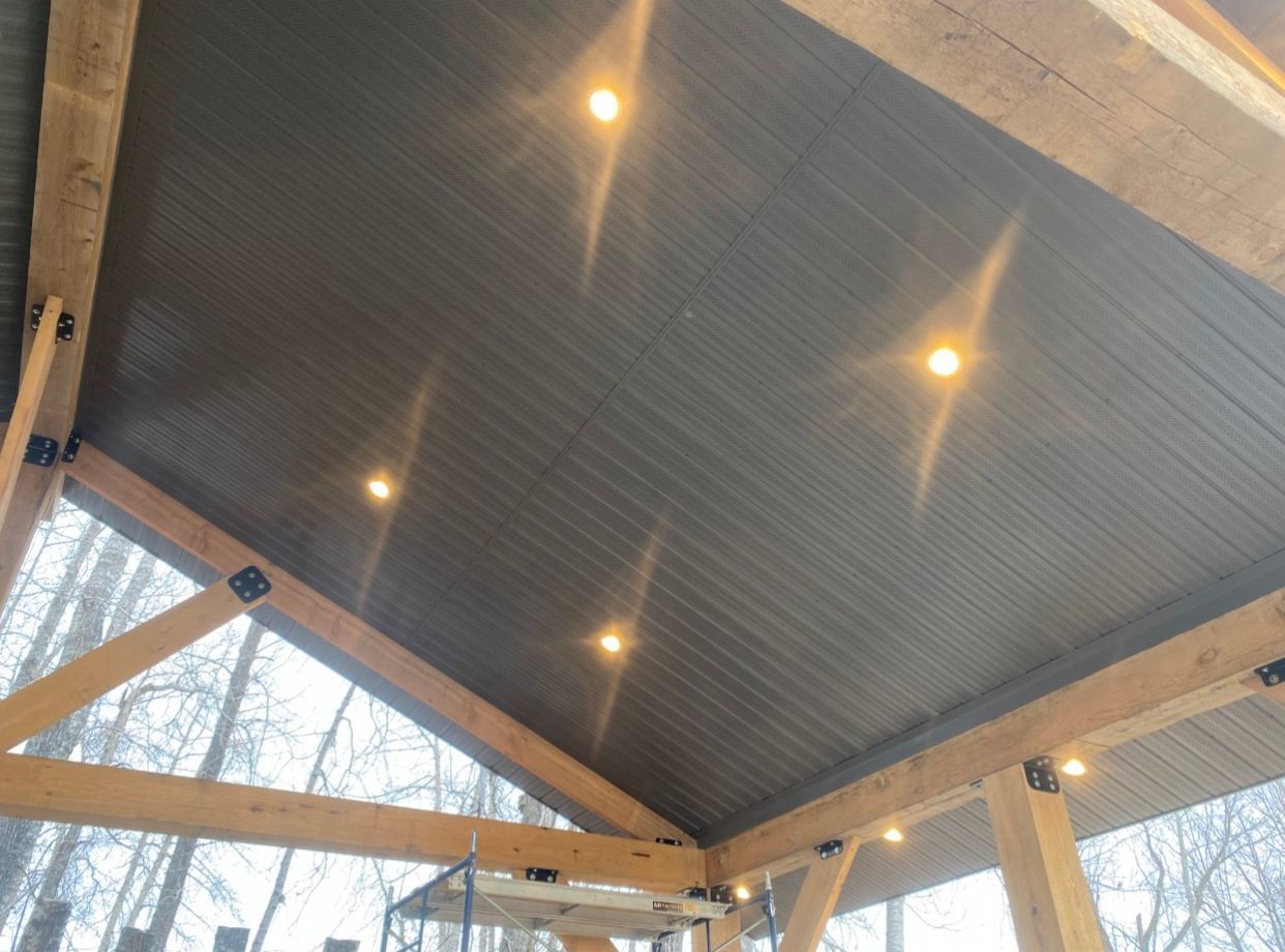 The ceiling of a wooden structure with lights on it.