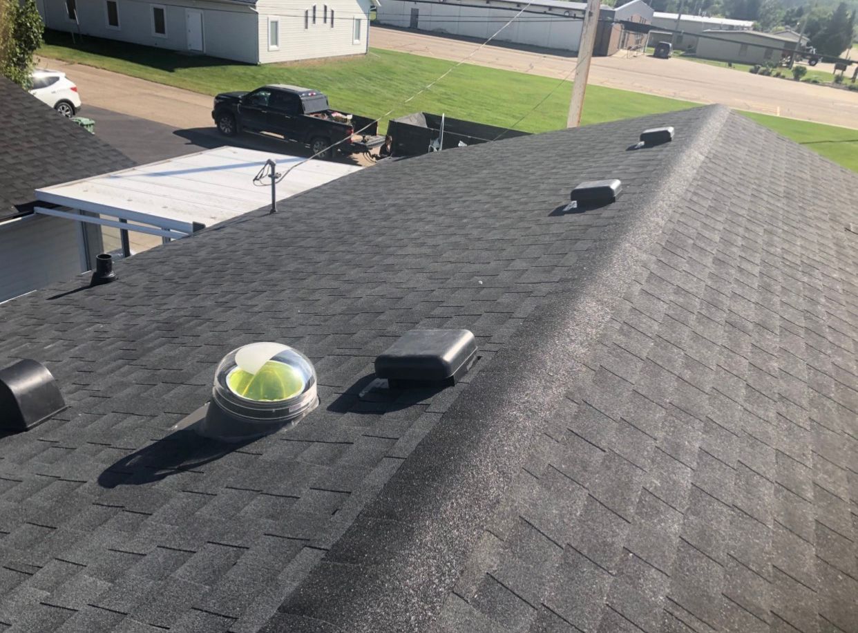 The roof of a house has a solar panel on it.