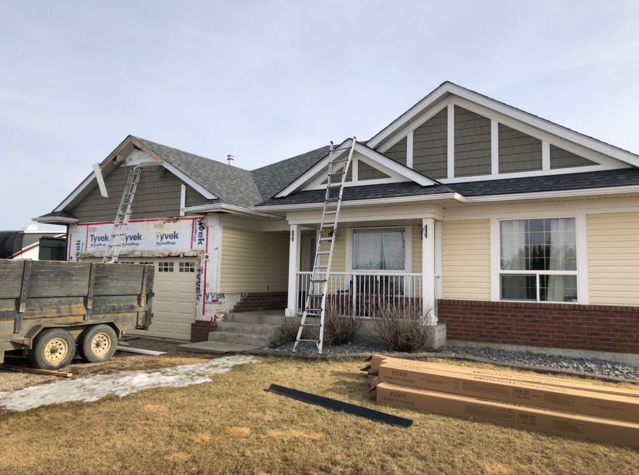 A house is being built with a ladder on the front of it.