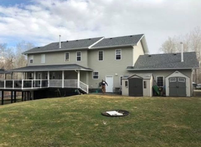 A large house with a large deck and a fire pit in the backyard.
