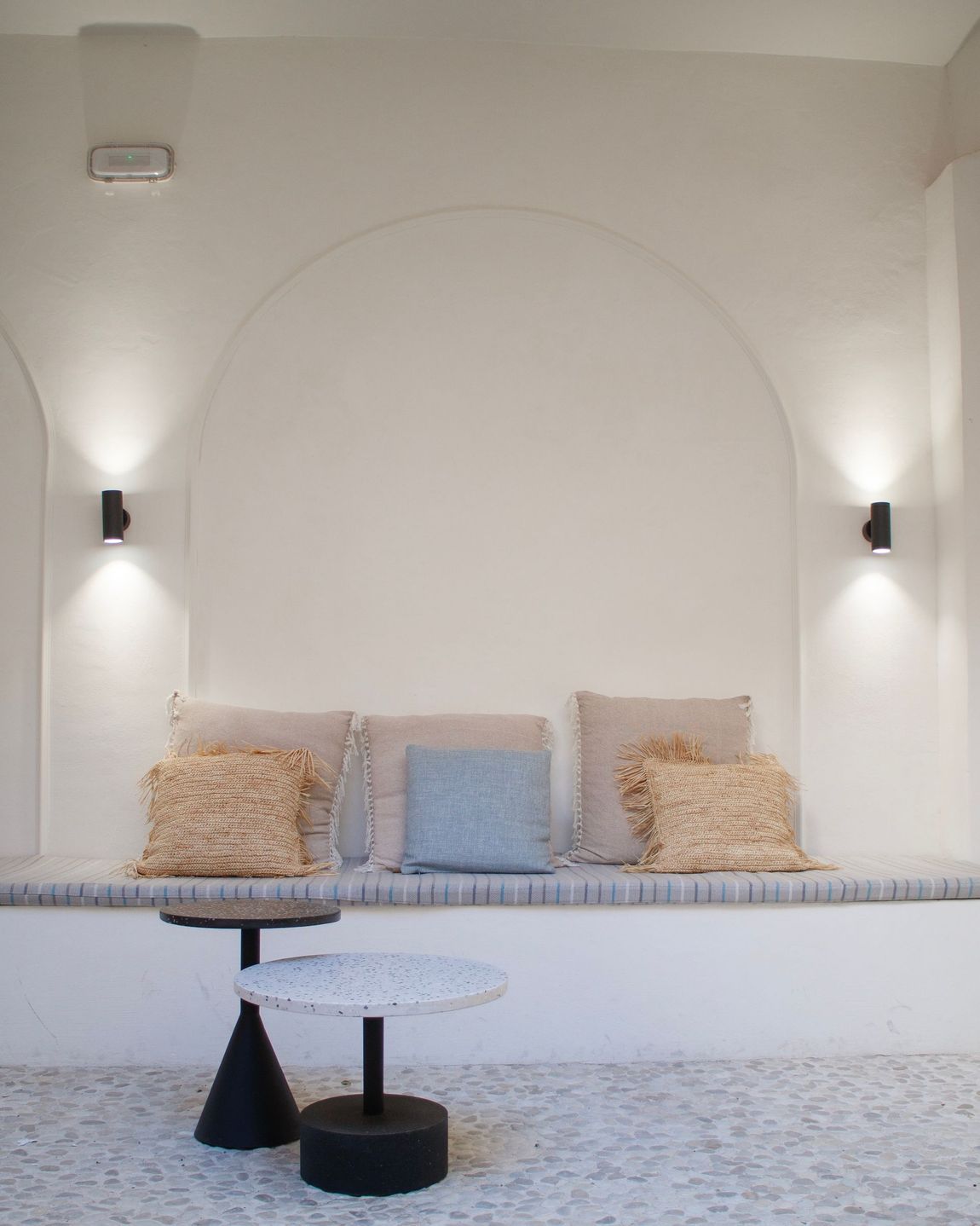 A white room with a couch and two tables
