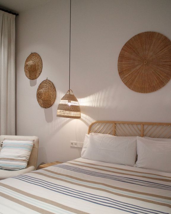 A bedroom with a bed and wicker baskets on the wall