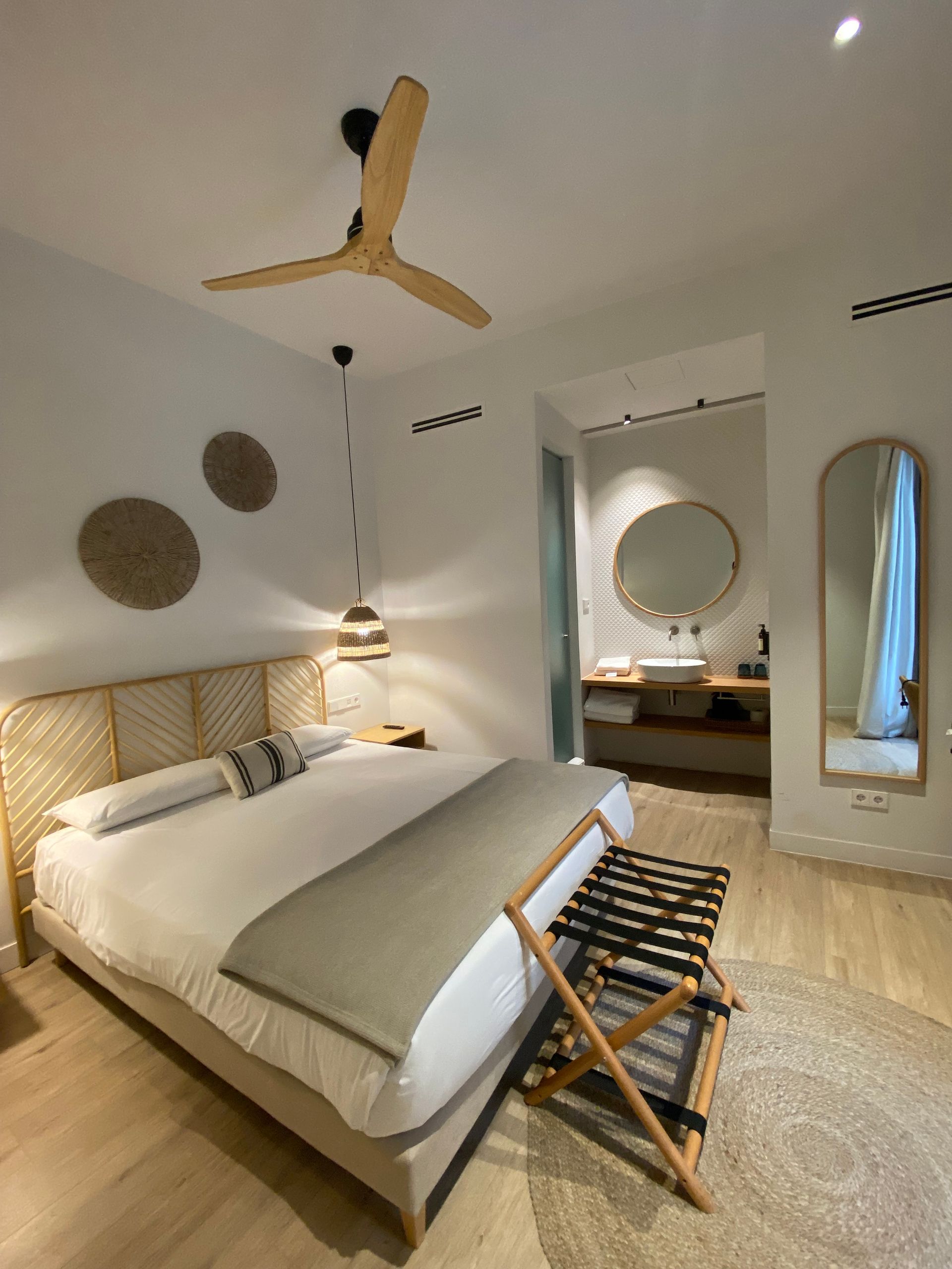 A bedroom with a large bed and a ceiling fan.