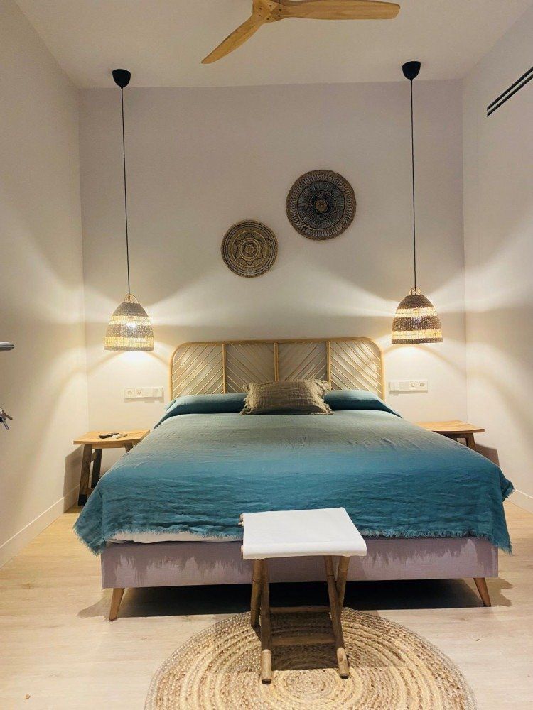 A bedroom with a large bed and a ceiling fan