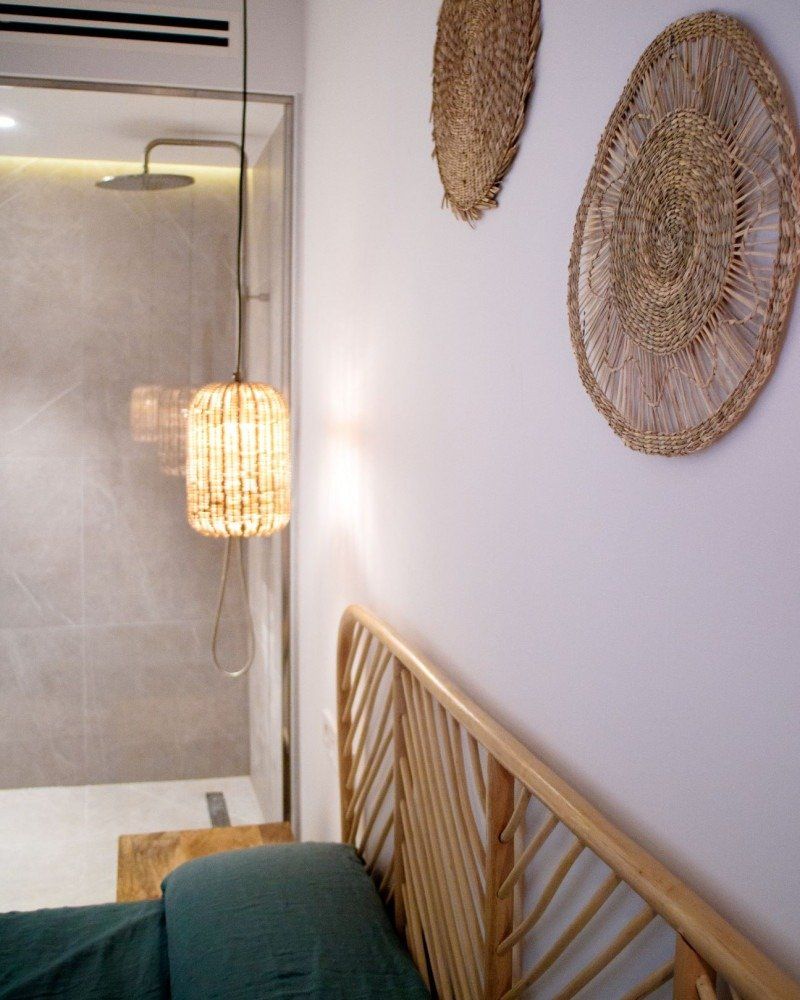 A bedroom with a wicker headboard and a shower