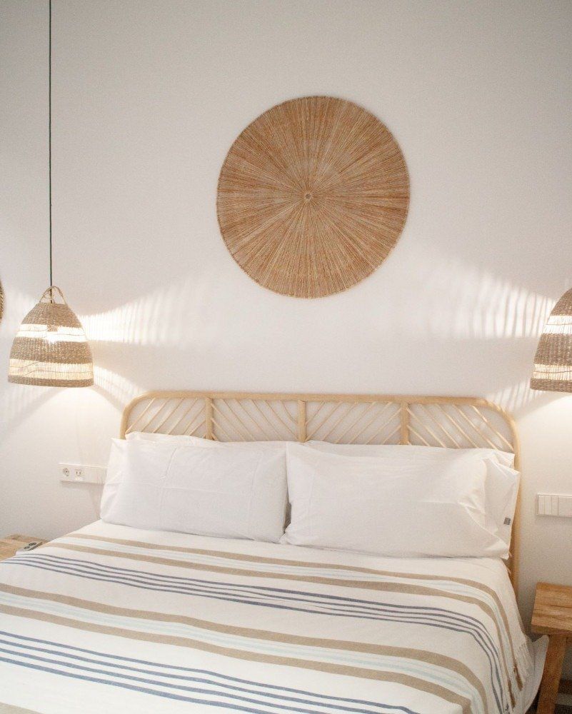 A bedroom with a bed and a wicker headboard