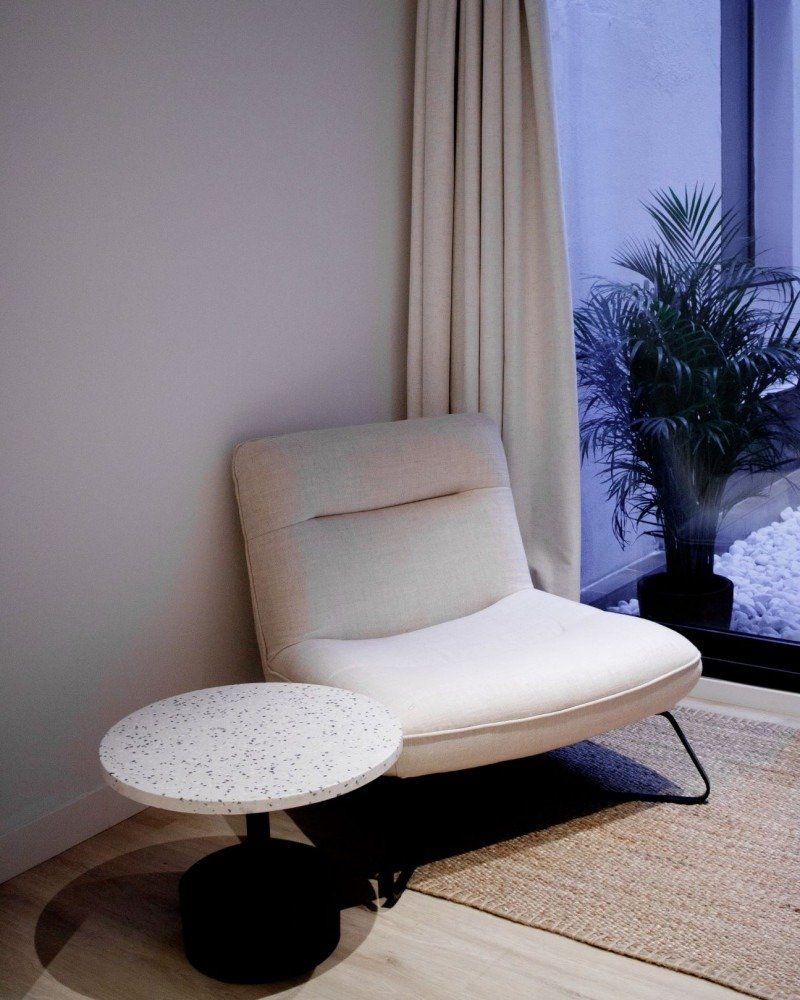 A chair and a table in a room next to a window.