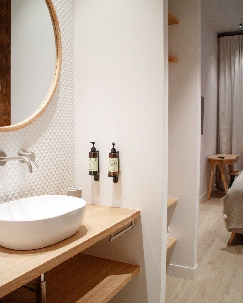 A bathroom with a sink and two soap dispensers on the wall