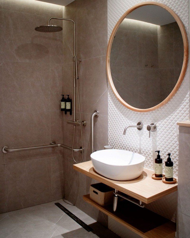 A bathroom with a sink , mirror and shower.