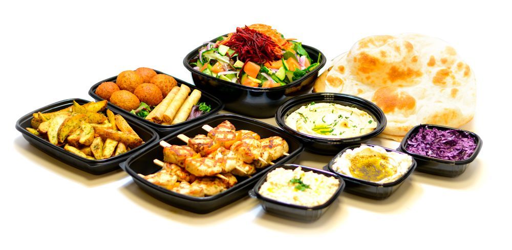 A variety of food in plastic containers on a table.