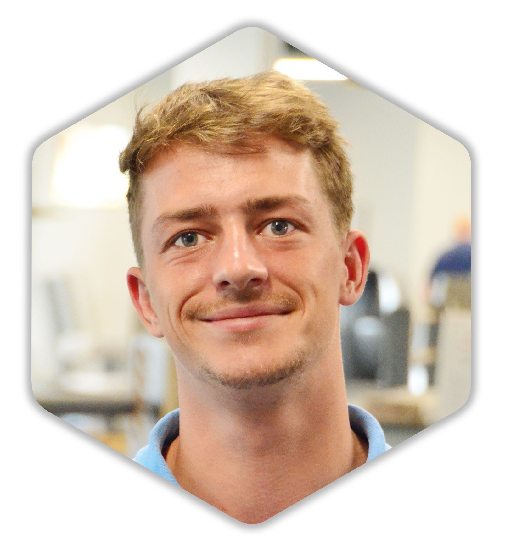 Ein Mann mit Bart lächelt und trägt ein blaues Hemd