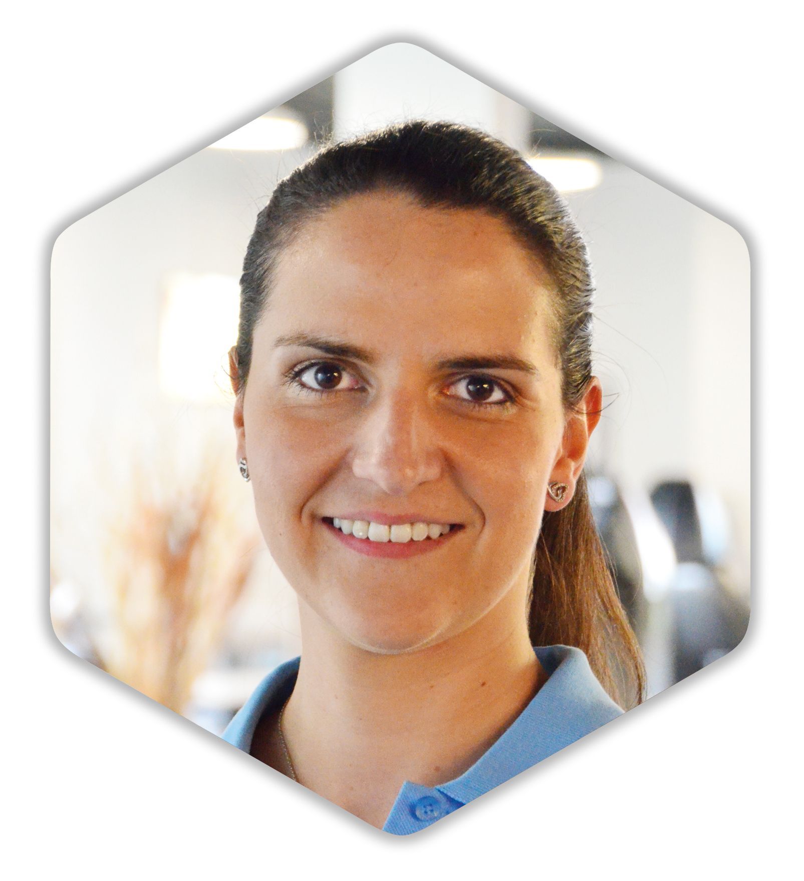 Eine Frau in einem blauen Hemd lächelt in die Kamera