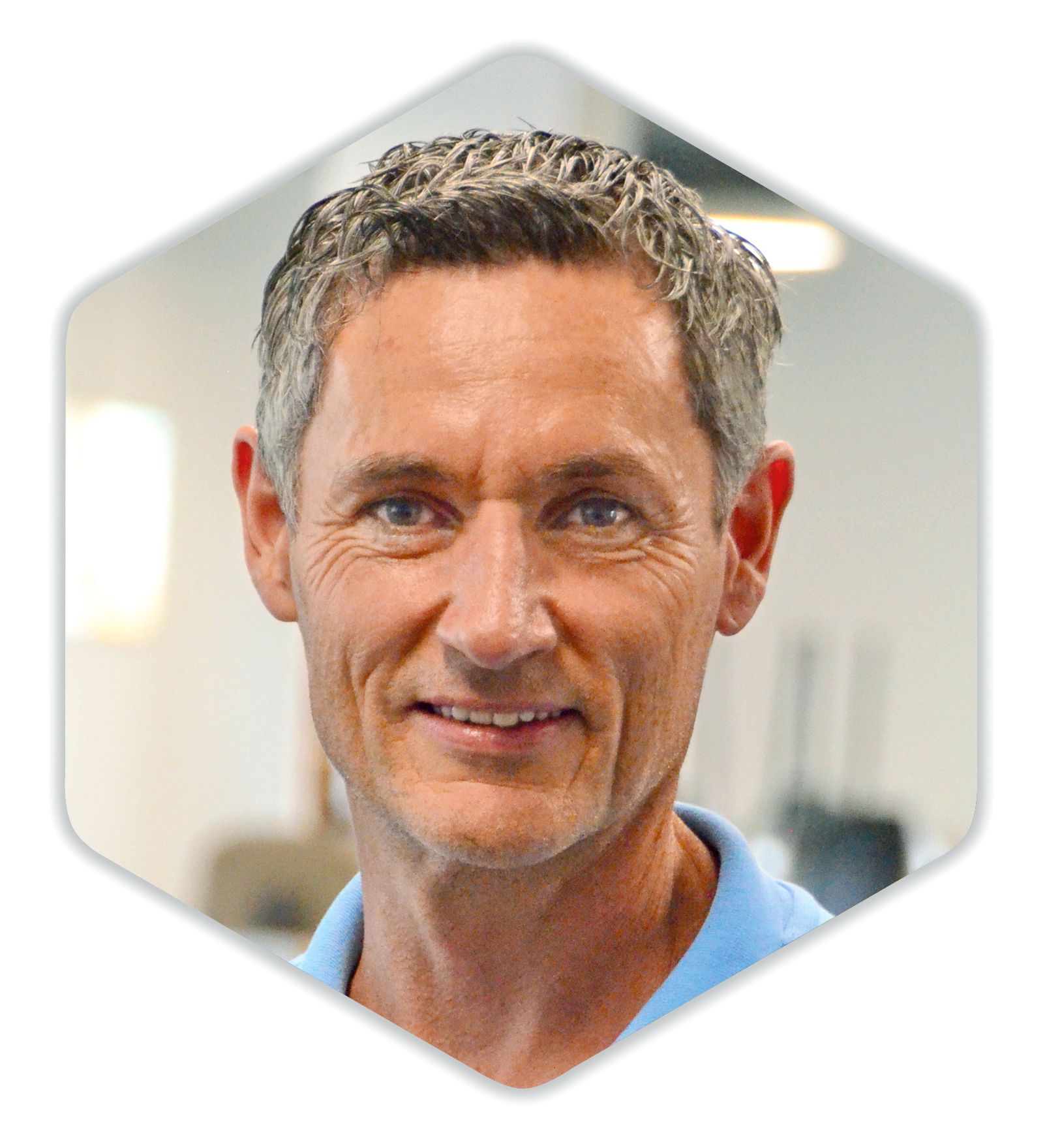 Ein Mann in einem blauen Hemd lächelt in die Kamera