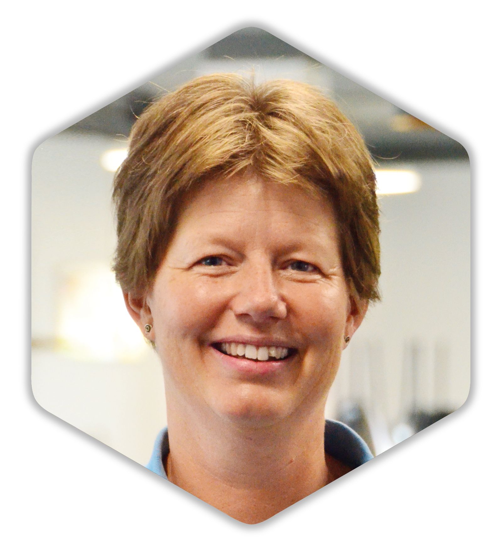 Eine Frau in einem blauen Hemd lächelt in die Kamera