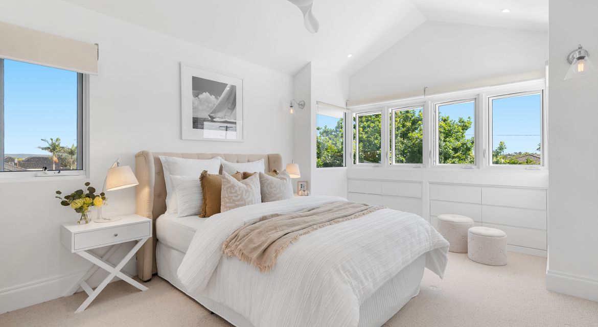 Cosy bedroom with feature wall in soft blue and clean ceiling finish