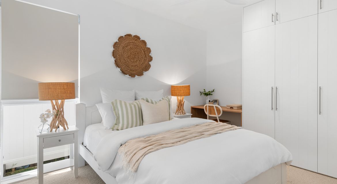 Cosy bedroom with feature wall in soft blue and clean ceiling finish