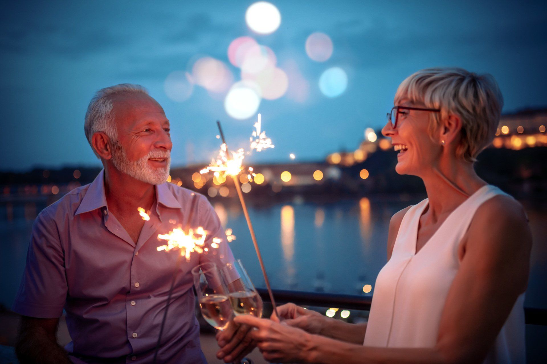 Elderly couple enjoying champagne and sparklers