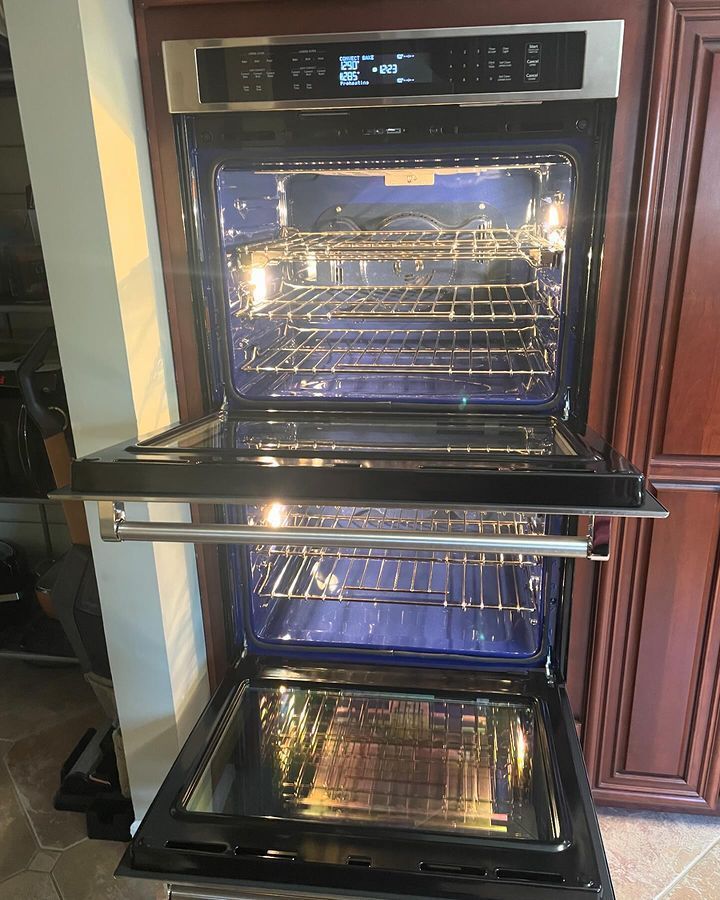 A double oven with the door open in a kitchen.
