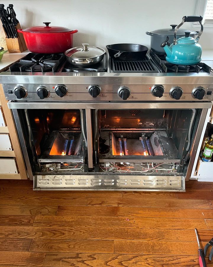 A stove with a lot of pots and pans on it in a kitchen.