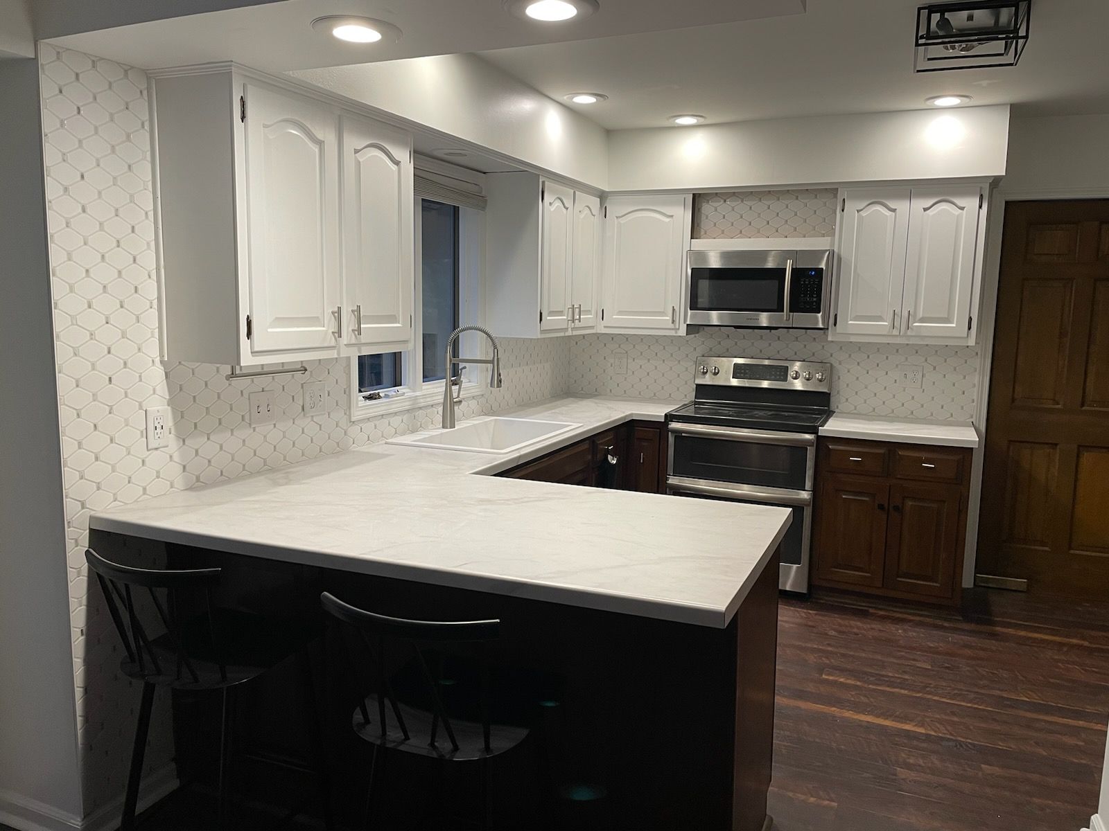 A kitchen with white cabinets and stainless steel appliances