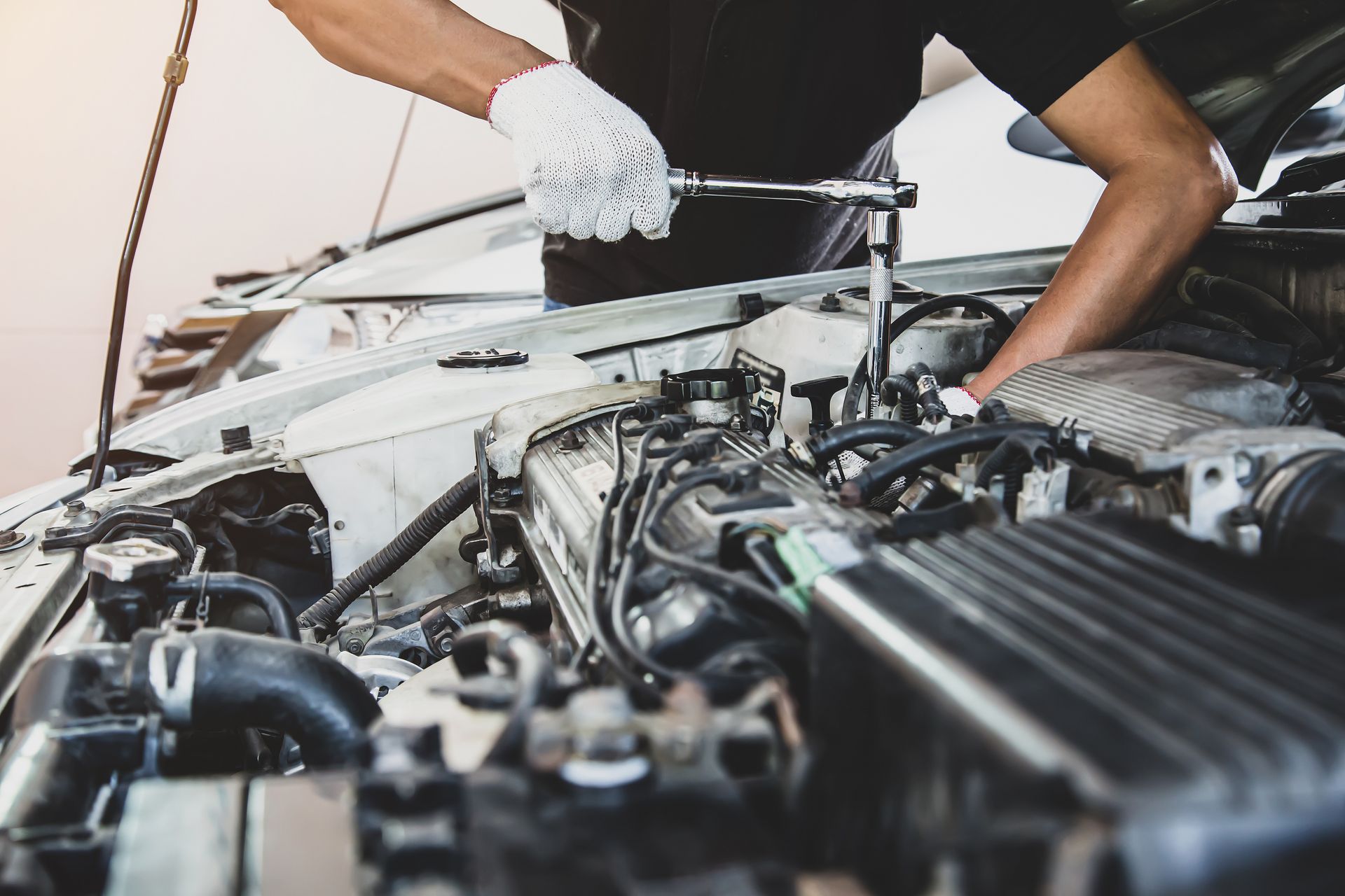 Mechanic tightening engine components during car repair. Mechanic tightening engine components during car repair.