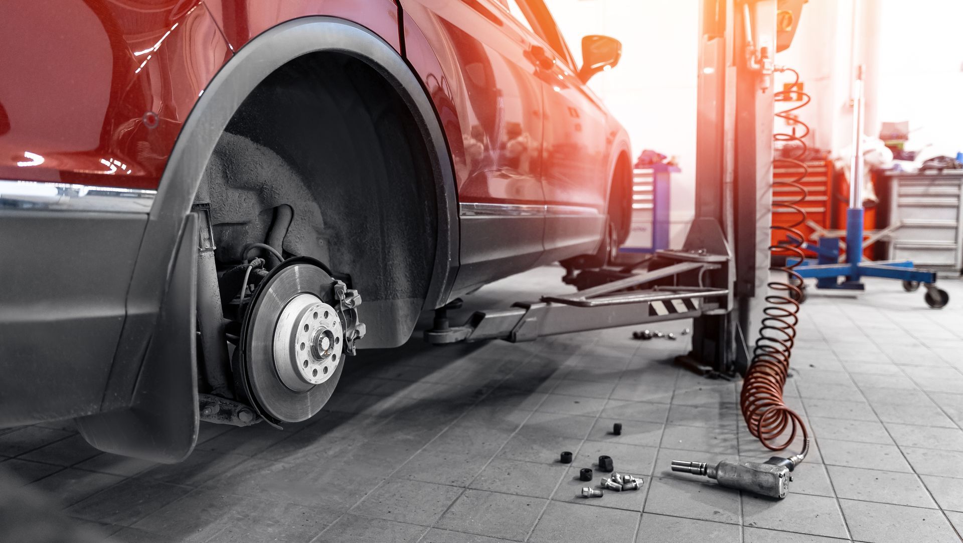 Closeup of steel brake disc in car service, showcasing expert auto mechanic replacing wheel pads.