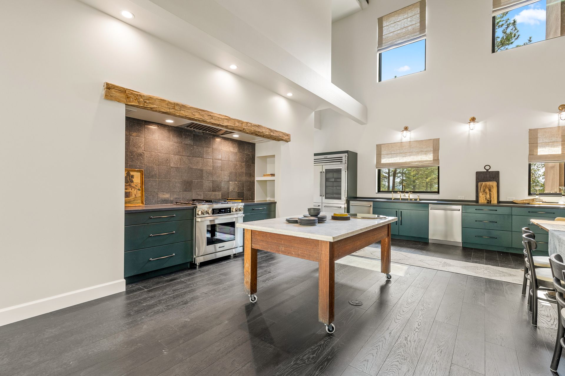 A large kitchen with a wooden table in the middle of it.