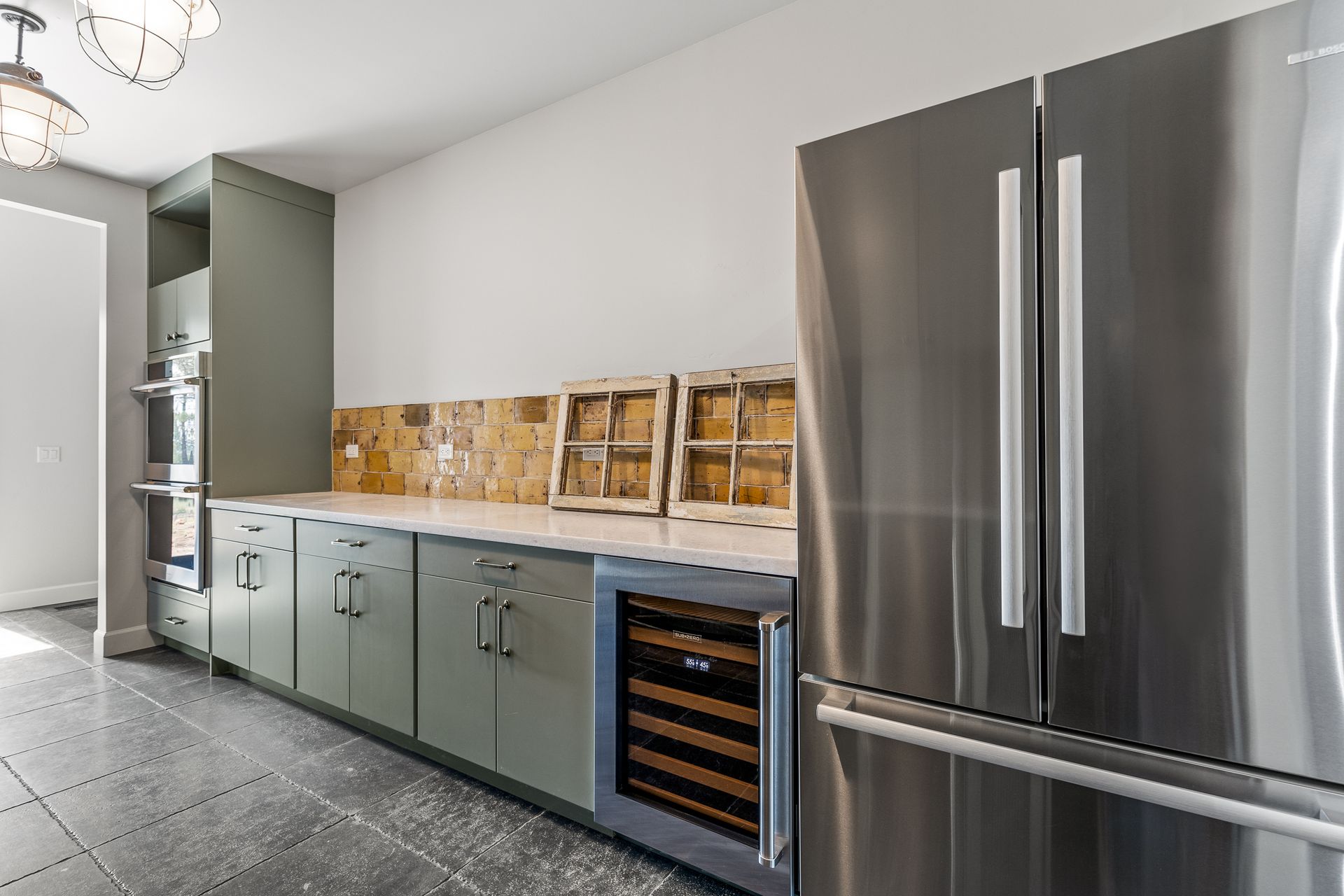 A kitchen with stainless steel appliances and a wine cooler.