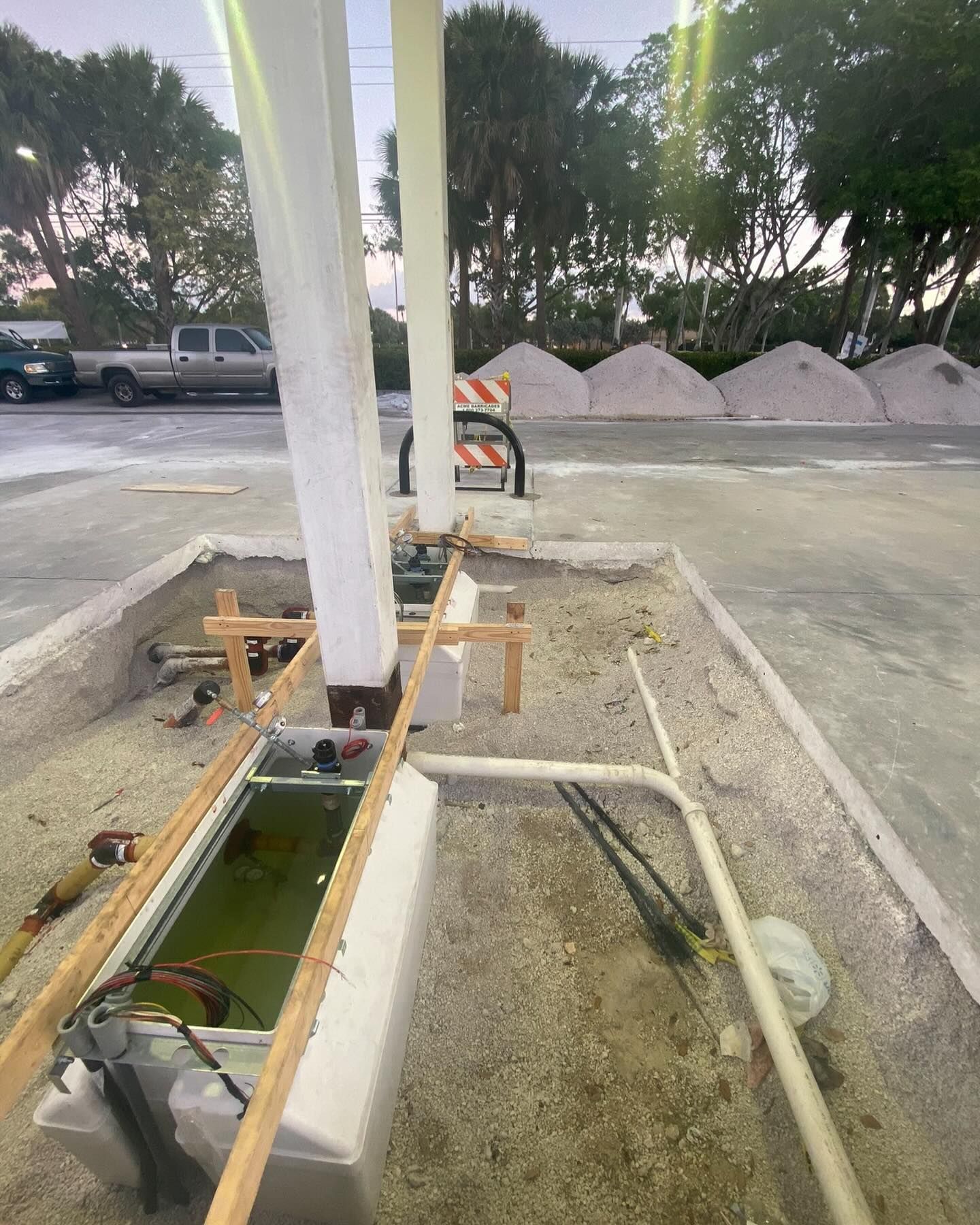 Construction worker carrying electrical cables. Wearing safety glasses and a cap, working indoors.