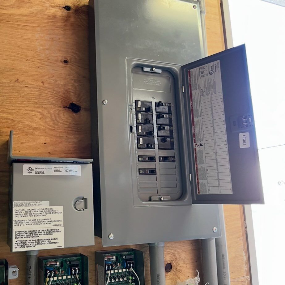 Construction worker holding electrical wires, near metal framing in a building.