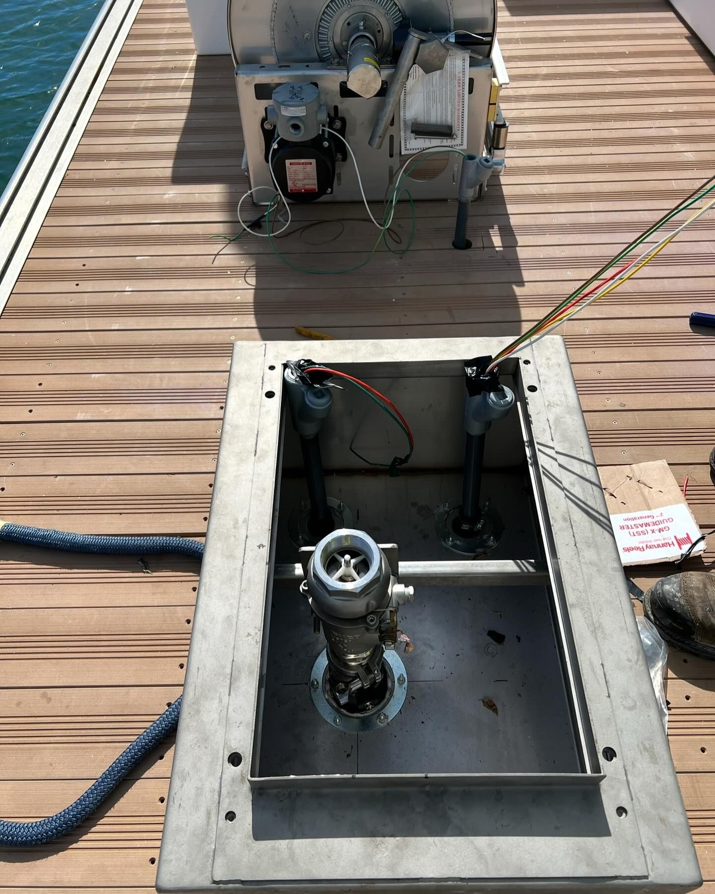 Construction worker carrying electrical cables. Wearing safety glasses and a cap, working indoors.