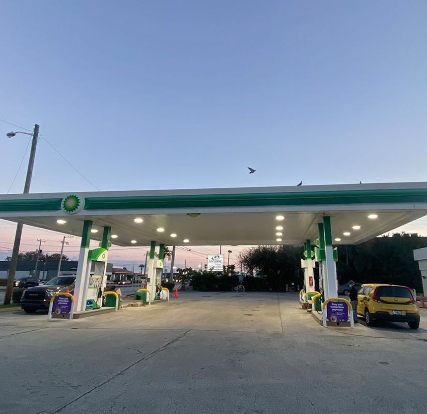 Construction worker carrying electrical cables. Wearing safety glasses and a cap, working indoors.