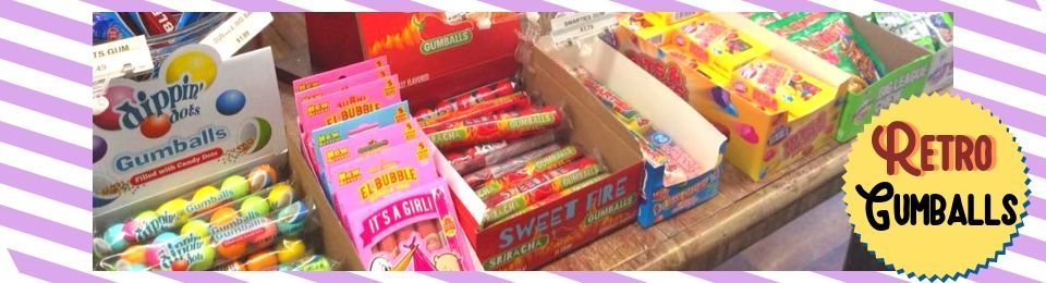 Assorted colorful retro gumballs and candy in display boxes with a “Retro Gumballs” sign