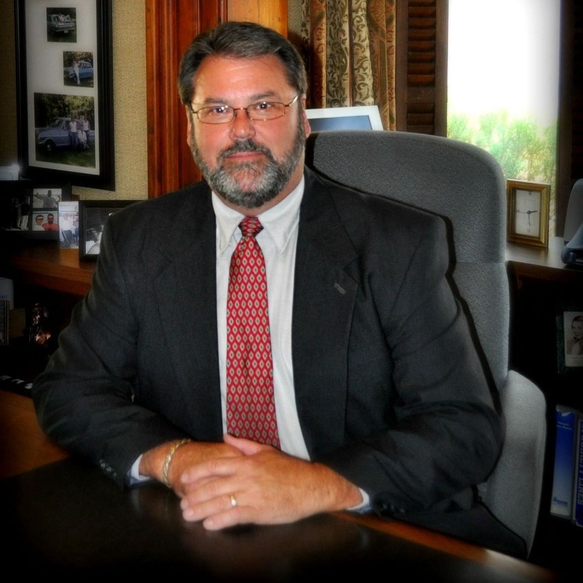 A man in a suit and tie is sitting at a desk