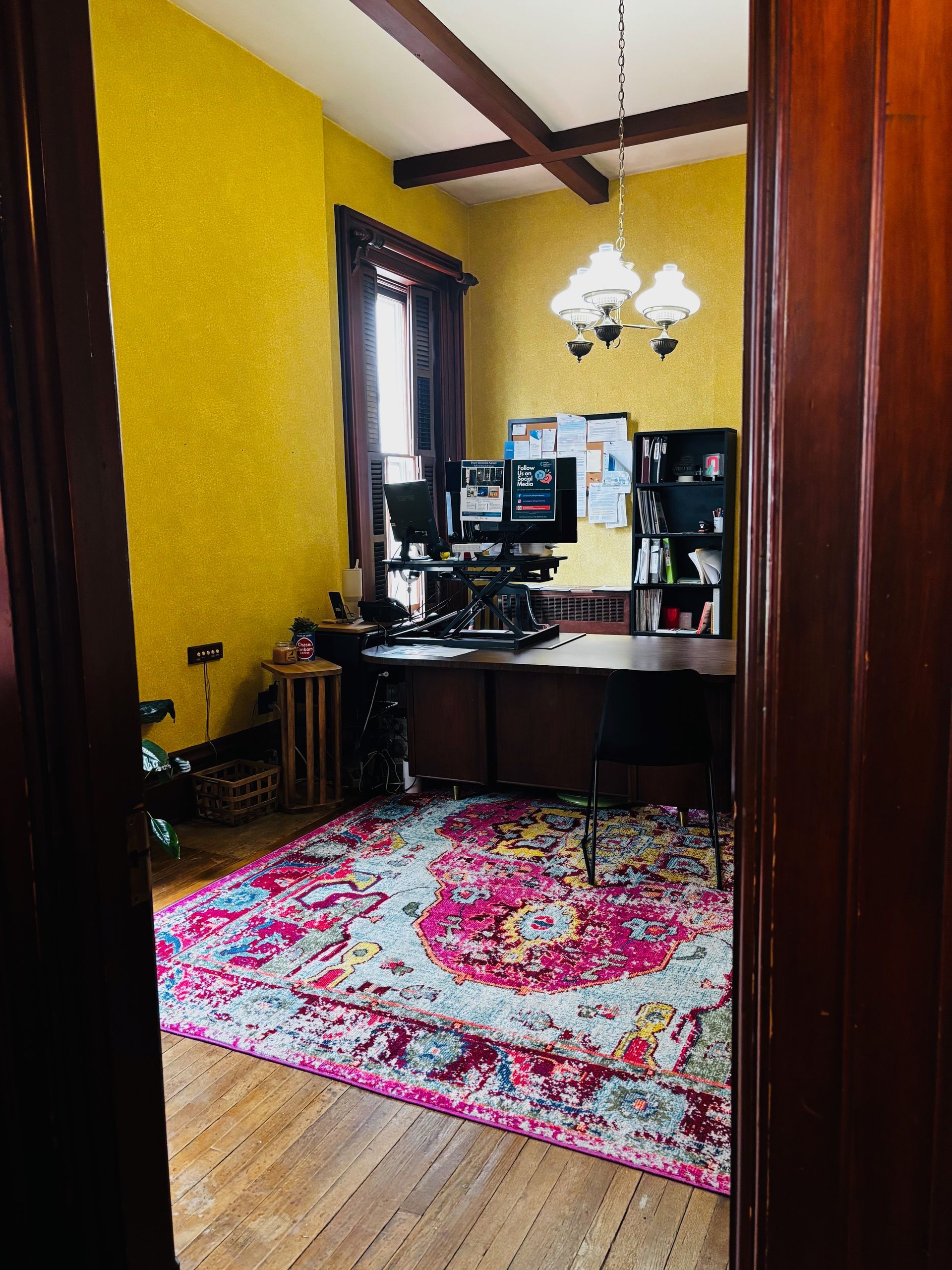 A room with yellow walls and a rug on the floor