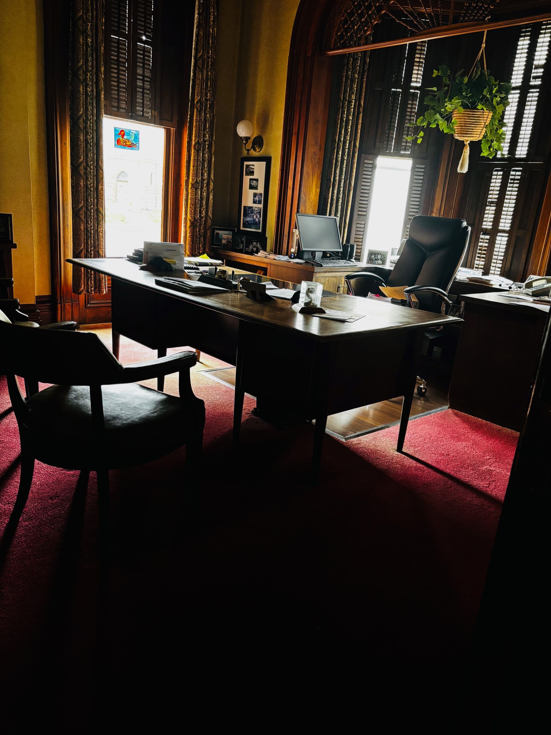 A dark room with a desk and chairs in it