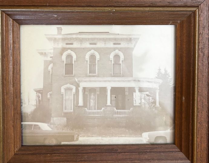 A picture of a house in a wooden frame