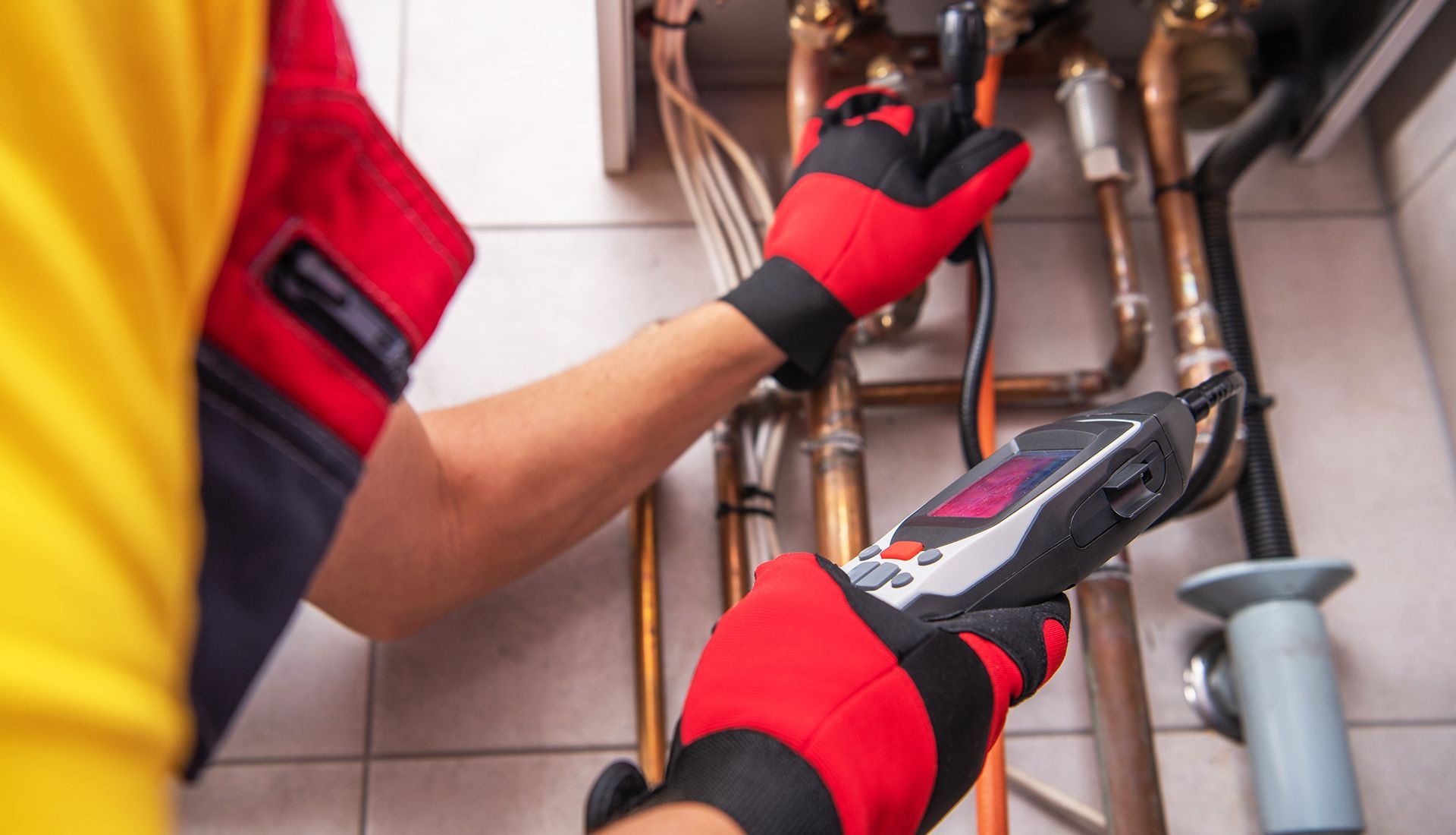 Person painting the trim of a house window, wearing white clothing, sunny day.