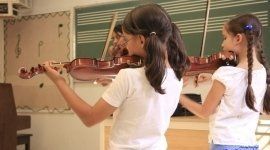 delle bambine che suonano il violino